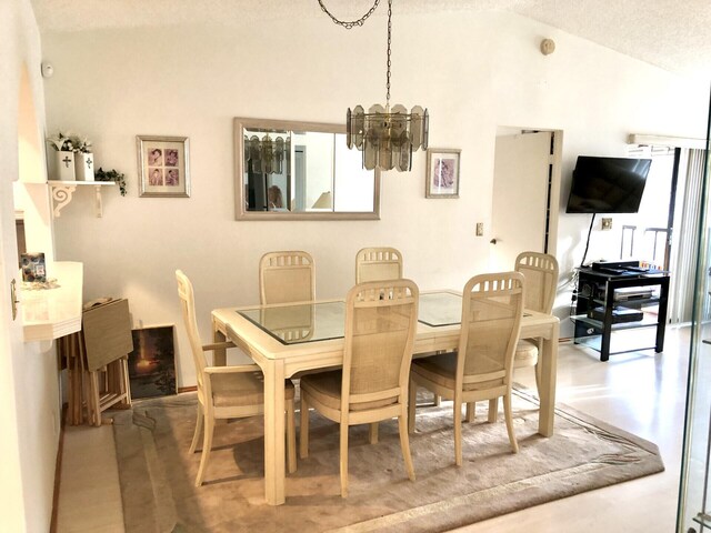 7633 S Tahiti Ln Unit 204, Lake Worth, FL 33467 - dining area featuring a chandelier and vaulted ceiling