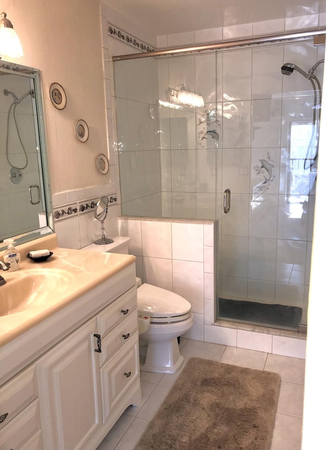 bathroom featuring vanity, an enclosed shower, tile walls, and tile patterned floors