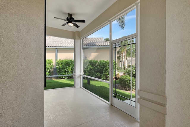 unfurnished sunroom with ceiling fan