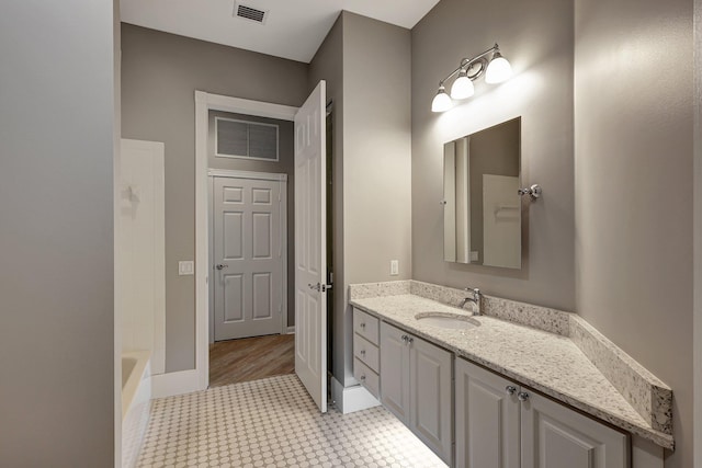 bathroom with hardwood / wood-style floors, a bathtub, and vanity