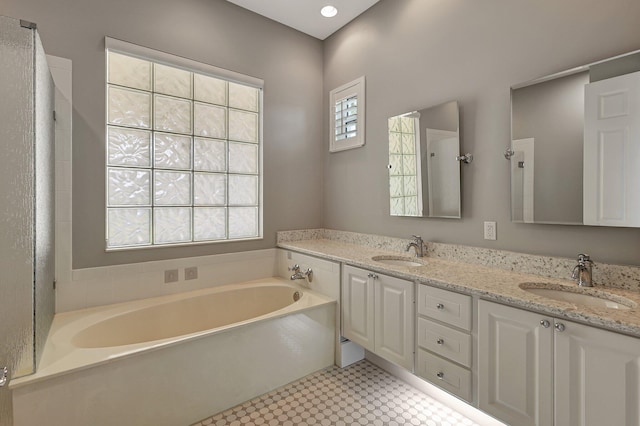 bathroom with a tub to relax in and vanity