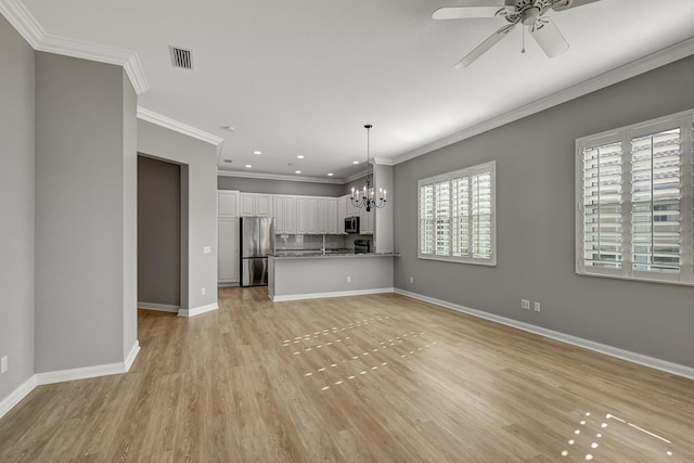 unfurnished living room with ceiling fan with notable chandelier, light hardwood / wood-style flooring, and crown molding