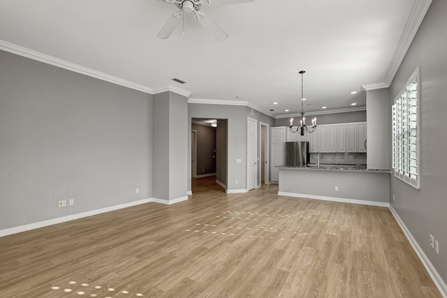 unfurnished living room featuring ornamental molding, ceiling fan with notable chandelier, light hardwood / wood-style flooring, and sink