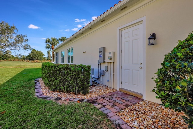 doorway to property with a lawn