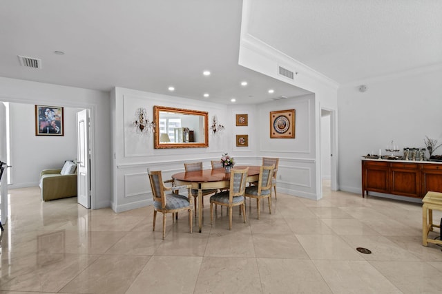 dining space featuring crown molding