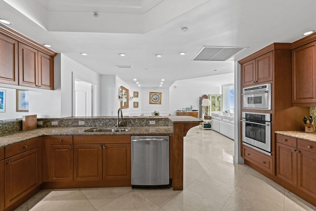 kitchen featuring sink, light tile patterned floors, dark stone counters, and appliances with stainless steel finishes