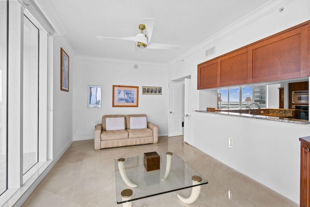 living room with ceiling fan and ornamental molding