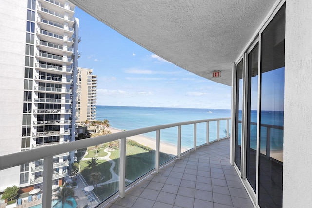 balcony featuring a water view and a beach view