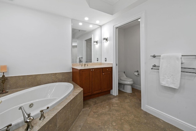 bathroom with vanity, toilet, and tiled tub