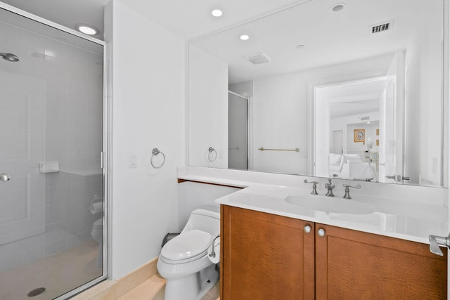 bathroom with a shower with door, vanity, and toilet