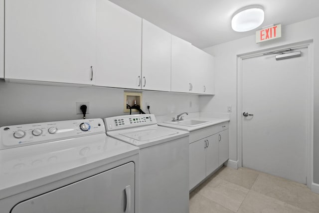 laundry room featuring light tile patterned flooring, cabinets, separate washer and dryer, and sink