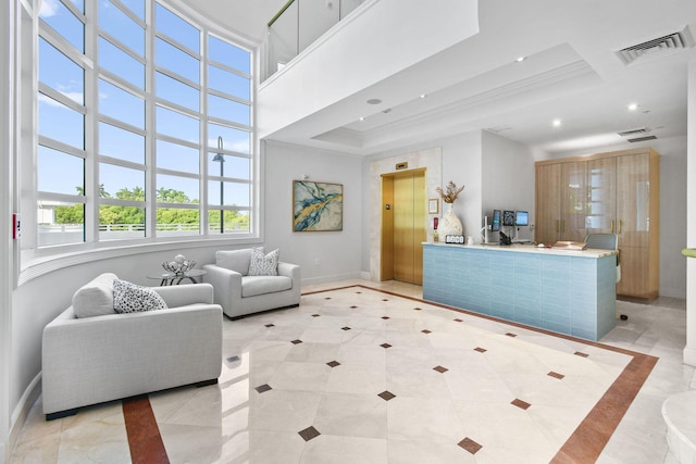 tiled living room featuring ornamental molding, elevator, and a towering ceiling