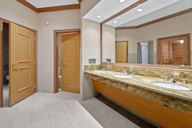 bathroom featuring tile patterned floors, crown molding, toilet, and tile walls