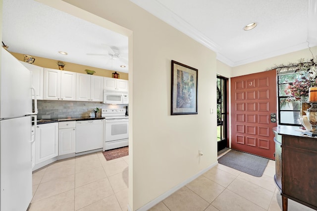 entryway with crown molding, light tile patterned floors, and ceiling fan