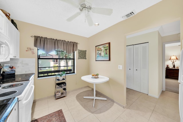 kitchen with ceiling fan, light tile patterned floors, white electric range, a textured ceiling, and white cabinets