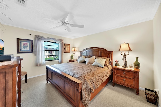 bedroom featuring a textured ceiling, light colored carpet, ceiling fan, and crown molding