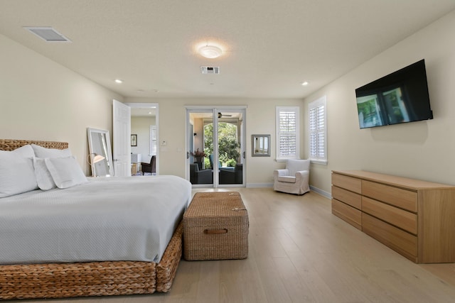 bedroom featuring access to exterior and light hardwood / wood-style flooring