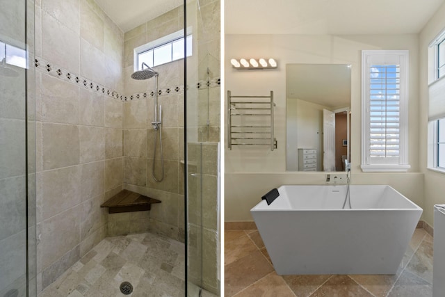 bathroom featuring a healthy amount of sunlight, separate shower and tub, and radiator