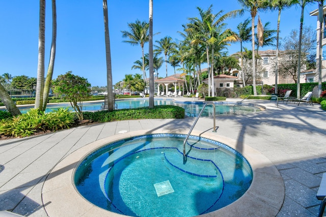 view of pool with a gazebo, a community hot tub, and a patio