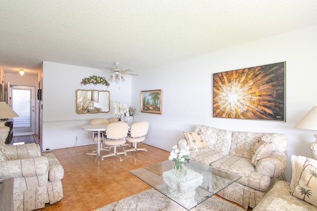 living room with a textured ceiling and ceiling fan