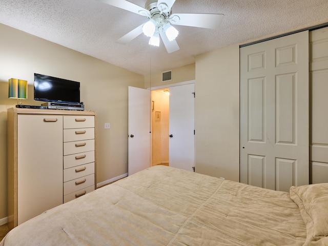 bedroom with ceiling fan and a textured ceiling