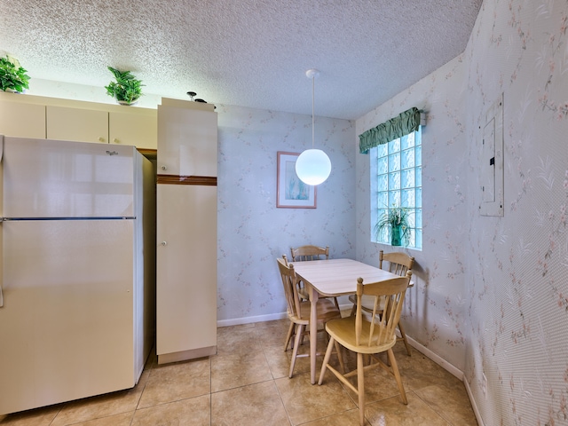 dining room with a textured ceiling and light tile patterned floors