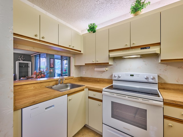 kitchen featuring cream cabinets, a textured ceiling, sink, butcher block countertops, and white appliances