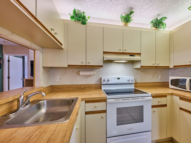 kitchen featuring wooden counters, a textured ceiling, sink, and white appliances