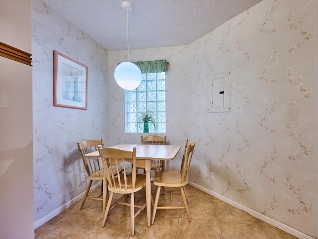 dining area with electric panel, a textured ceiling, and light tile patterned floors