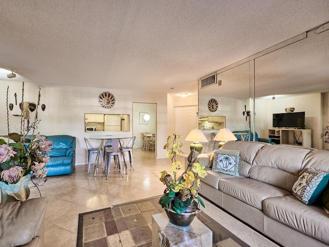 tiled living room featuring a textured ceiling