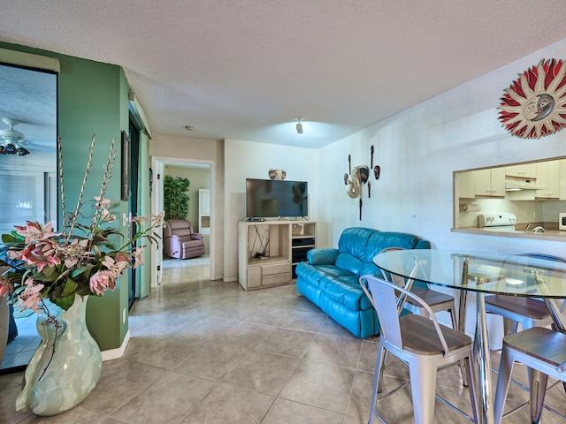 tiled living room with a textured ceiling and ceiling fan