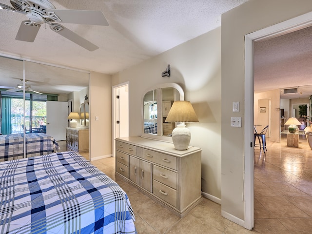 bedroom featuring light tile patterned flooring, a textured ceiling, and ceiling fan