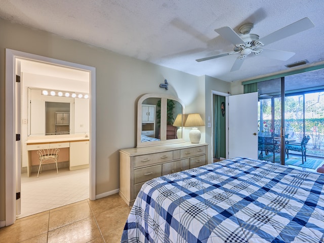 tiled bedroom featuring a textured ceiling, access to exterior, ceiling fan, and ensuite bath