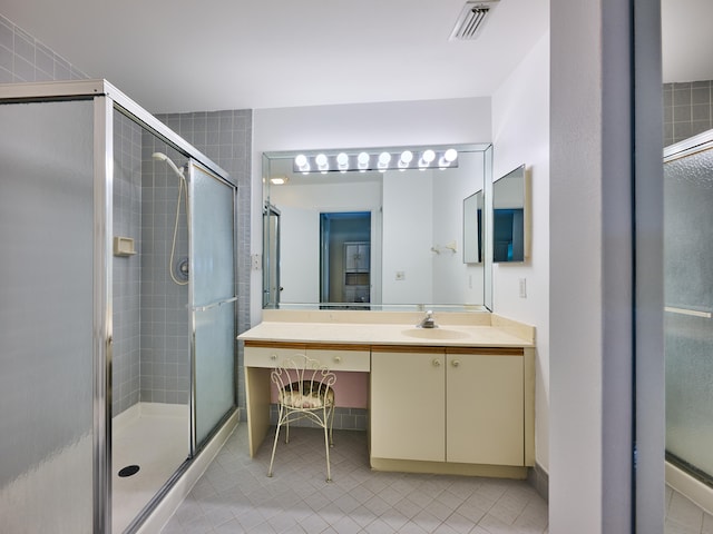 bathroom featuring tile patterned floors, vanity, and a shower with door