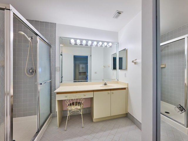 bathroom with vanity, tile patterned floors, and a shower with door