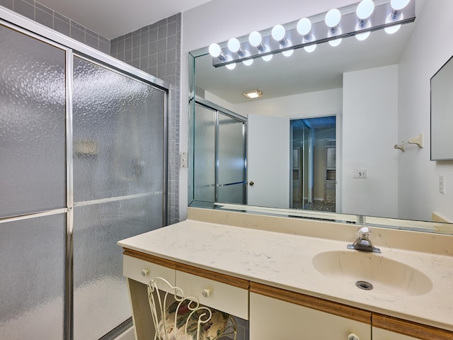 bathroom featuring walk in shower and vanity