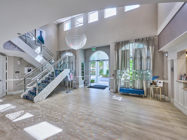 gym with a healthy amount of sunlight, a high ceiling, and an inviting chandelier