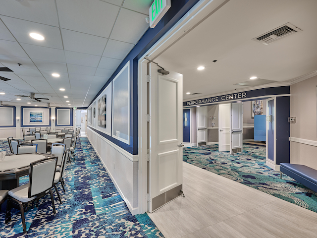 corridor with ornamental molding, carpet floors, and a drop ceiling