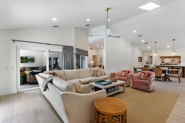 living room with high vaulted ceiling, light wood-type flooring, and ceiling fan