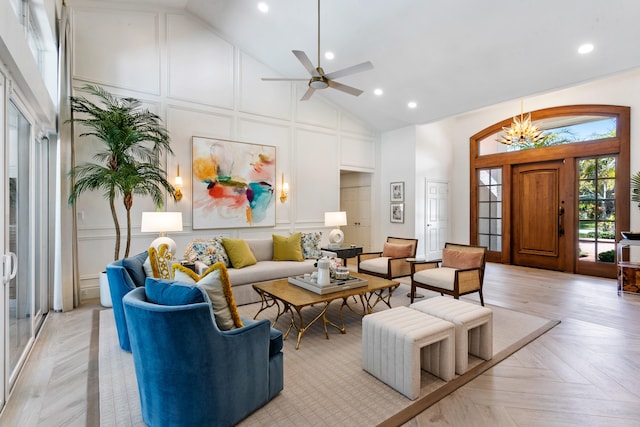 living room with light parquet flooring, high vaulted ceiling, and ceiling fan with notable chandelier