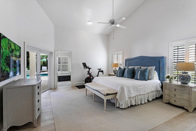 bedroom featuring ceiling fan, high vaulted ceiling, multiple windows, and light wood-type flooring