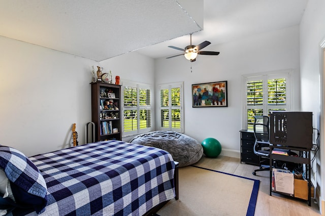 bedroom featuring light hardwood / wood-style floors, a textured ceiling, and ceiling fan