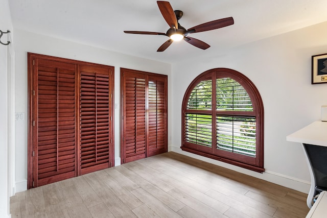 unfurnished bedroom with ceiling fan and light wood-type flooring