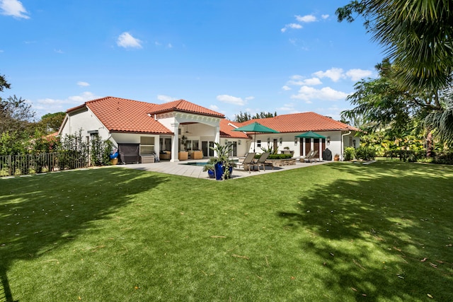 rear view of property with a patio and a lawn