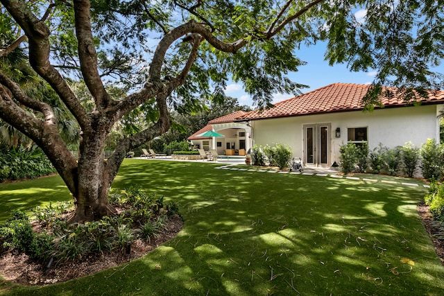 back of house featuring french doors, a yard, and a patio