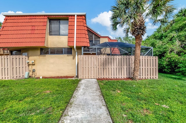 view of property exterior featuring a lanai and a lawn