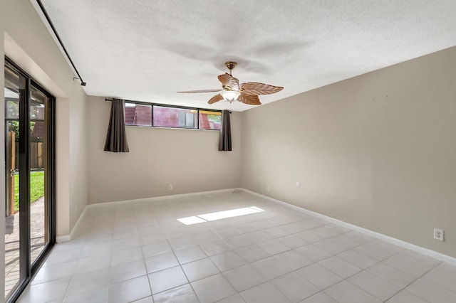 tiled spare room featuring ceiling fan, a healthy amount of sunlight, and a textured ceiling