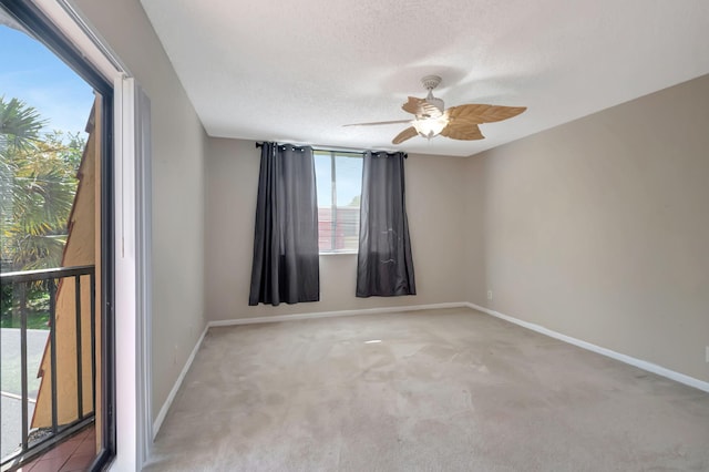 empty room featuring light carpet, a textured ceiling, and ceiling fan