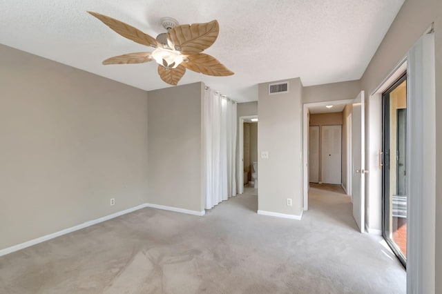 unfurnished room with light carpet, a textured ceiling, and ceiling fan