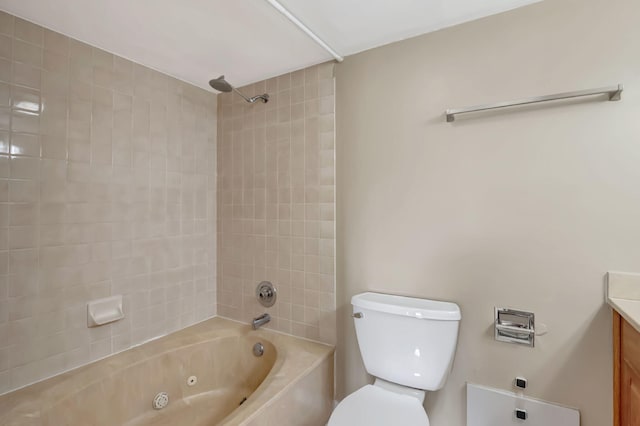 full bathroom featuring tiled shower / bath, vanity, and toilet